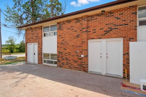 A red brick house with a white door and windows.
